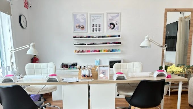 Interior del salón Arte y Miradas en Oviedo: mesas de manicura con lámparas profesionales y muestrario de esmaltes
